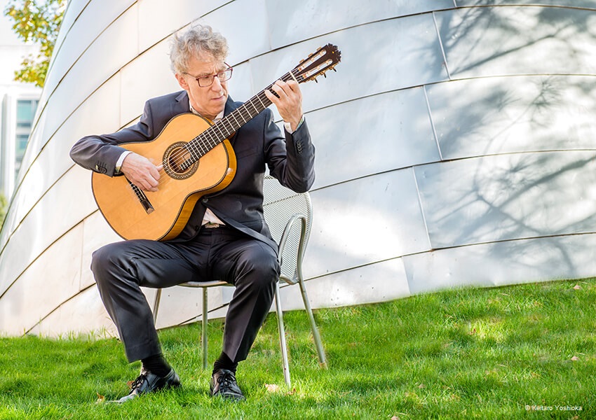 Eliot-Fisk-lineup Eliot Fisk spielt auf Wiese mit Gitarre