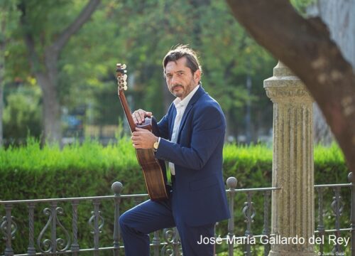 José María Gallardo del Rey mit Gitarre vor Hecke
