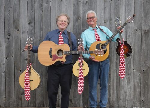 Matching-Ties-gallerie Duo Matching Ties mit Gitarren und Krawatten vor Holzwand