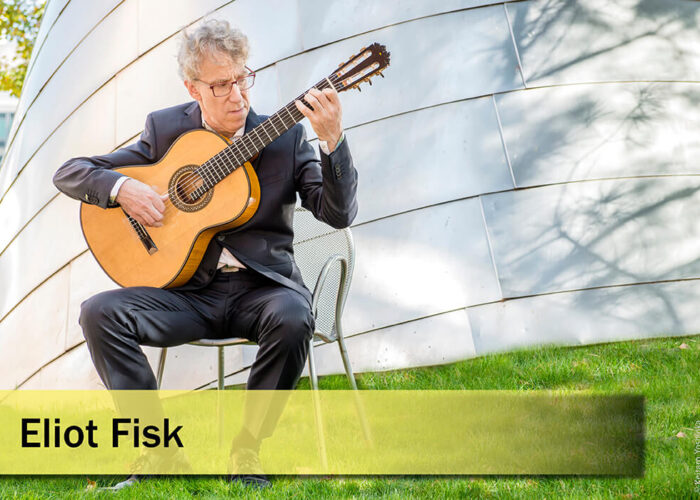 Slider-Künster-Eliot-Fisk Eliot Fisk spielt in schwarzem Anzug draußen Gitarre